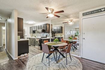 A kitchen with a dining table and chairs in the middle of the room